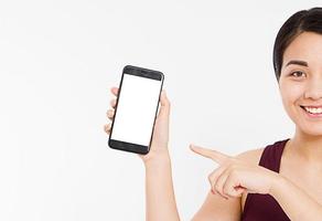 bijgesneden portret Aziatische, Koreaanse vrouw, meisje houdt leeg scherm mobiel, vinger wijzend geïsoleerd op witte achtergrond, hand met zwarte telefoon, kopieer ruimte foto