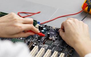 vrouwelijke technicus met een hoge hoek die het moederbord van de computer repareert