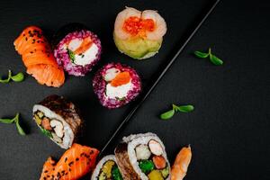 divers sushi, Japans lunch en kant gerechten en dompelen teriyaki saus Aan donker achtergrond. kant visie van deel van Japans sushi broodjes set. Aziatisch keuken. vrij ruimte voor uw tekst. foto