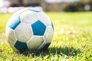 wit-blauwe bal op het groene gras. ruimte kopiëren. zomer- of lentetijd. hete zon. sportief voetbal. foto