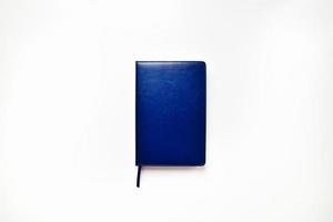 vooraanzicht van marineblauw notitieboekje dat tegen witte achtergrond wordt geïsoleerd