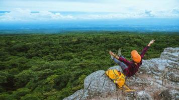 vrijheid reiziger vrouw genieten van een kijken naar de natuur van de bergen op de kliffen tegen een prachtig landschap tijdens de zomer reis ontspannen in de buitenlucht. reis rugzak foto