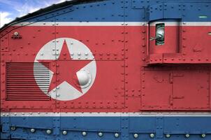 noorden Korea vlag afgebeeld Aan kant een deel van leger gepantserd tank detailopname. leger krachten conceptuele achtergrond foto