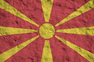 Macedonië vlag afgebeeld in helder verf kleuren Aan oud Verlichting bepleistering muur. getextureerde banier Aan ruw achtergrond foto