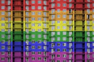 lgbt gemeenschap vlag afgebeeld in verf kleuren Aan meerdere verdiepingen woonachtig gebouw onder bouw. getextureerde banier Aan steen muur achtergrond foto
