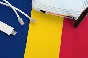 Tsjaad vlag afgebeeld Aan tafel met internet rj45 kabel, draadloze USB Wifi adapter en router. internet verbinding concept foto