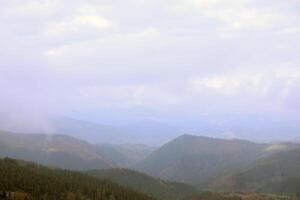 ochtend- visie van de dragobrat berg pieken in Karpaten bergen, Oekraïne. bewolkt en mistig landschap in de omgeving van drahobrat pieken foto