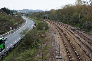 spoorlijnen en weg die aankomen op oviedo. groen scenario en stad op de achtergrond foto