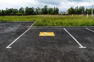 een geel teken Aan de asfalt shows een parkeren plaats voor mensen met handicap, voor de gehandicapt, een weg teken, markeringen Aan de weg foto