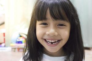 kleine meisjesglimlach verliest zijn eerste tand foto