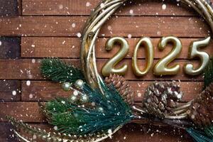 gelukkig nieuw jaar gouden getallen 2025 Aan knus feestelijk bruin houten achtergrond met pailletten, sneeuw, lichten van slingers. hartelijk groeten, ansichtkaart. kalender, Hoes foto