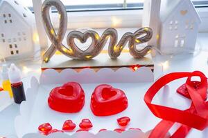 handgemaakt eigengemaakt zeep in de vorm van harten voor een Valentijnsdag dag geschenk naar uw geliefde. parfums en kleurstoffen, zeep baseren Aan de tafel foto