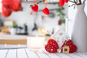 sleutel naar klein huis van knus huis met Valentijn decor Aan tafel van keuken. geschenk voor valentijnsdag dag, familie liefde nest. ontwerp, projecteren, in beweging naar nieuw huis, hypotheek, huur en aankoop echt landgoed foto