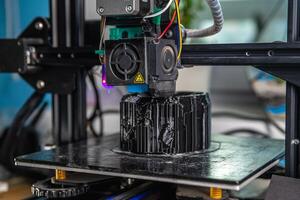 een 3d printer prints een zwart model. technologie Bij huis foto