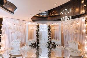 de bruiloft tafel van de bruid en bruidegom, versierd met bloemen, wit tule, gemaakt in licht roze kleur. bloemen Aan staat. bruiloft details. licht foto