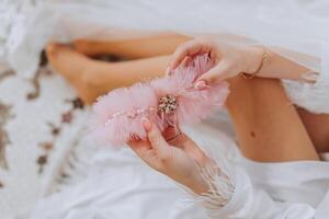 roze kousenband van de bruid. mooi ondergoed. de ochtend- van de bruid in detail. voorbereiding voor de bruiloft ceremonie foto
