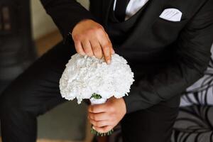 elegant portret van de bruidegom met een boeket van bloemen. een Mens is voorbereidingen treffen voor een bruiloft ceremonie in de ochtend. bruidegom ochtend. voorbereiding voor de bruidegom ochtend. jong en knap bruidegom. foto