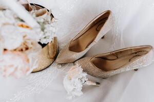 de bruid verloving ring, modieus stiletto's, vers roos bloemen. bruiloft details in gouden stijl. foto