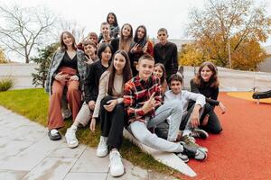 vriendschap, beweging, actie, vrijheid en mensen concept - groep van gelukkig tieners of school- vrienden poseren en hebben pret buitenshuis Aan achtergrond van mooi plaats of middelbare school. foto