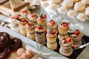 amandel koekjes en divers zoet cakes voor een bruiloft banket. een heerlijk ontvangst, een luxueus ceremonie. tafel met snoepgoed en desserts. heerlijk kleurrijk Frans desserts Aan een bord of tafel. foto