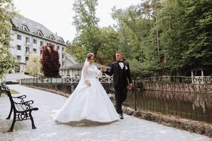 portret van een jong bruid en bruidegom wandelen in een mooi park na de bruiloft ceremonie, voorkant visie. gelukkig bruiloft stel, kopiëren ruimte foto