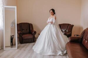 de bruid in haar bruiloft jurk poses in haar kamer. portret van de bruid. foto