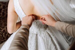 bijgesneden foto van vriendinnetjes helpen de bruid krijgen gekleed. voorbereiding. ochtend- van de bruid
