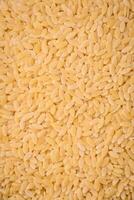 rauw risoni pasta gemaakt van durum tarwe Aan een donker beton achtergrond foto