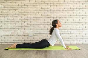 latijnse vrouw die yoga beoefent op mat foto