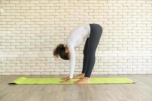 latijnse vrouw die yoga beoefent op mat foto