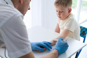 een mannetje dokter maakt een belangrijk mantoux test Aan een kind. de dokter maatregelen de mantoux test met een heerser voor een weinig jongen foto