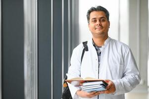 portret van een jong Indisch mannetje medisch leerling in een wit jas golvend foto