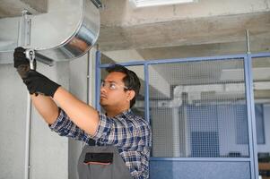 specialist reinigt en reparaties de muur lucht conditioner foto