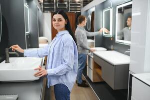 jong familie paar kiezen badkamer wastafel in badkamer armaturen op te slaan foto