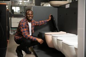 Afrikaanse Amerikaans Mens kiezen huis toilet in op te slaan foto