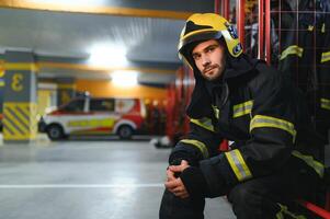 brandweerman zittend Aan bank Bij brand station foto