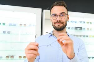 jong Mens kiezen bril Bij optiek winkel foto