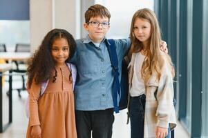 groep van elementair school- kinderen in een school- gang foto