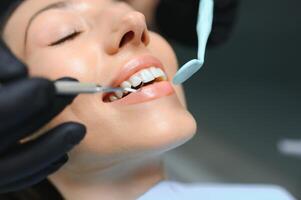 tandarts die de tanden van een patiënt in de tandarts onderzoekt foto