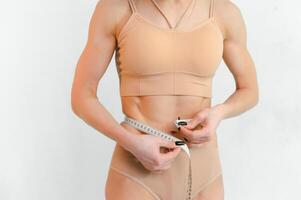 vrouw meten haar slank lichaam geïsoleerd Aan wit achtergrond foto
