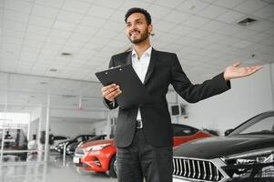 Indisch vrolijk auto verkoper Bij toonzaal. foto