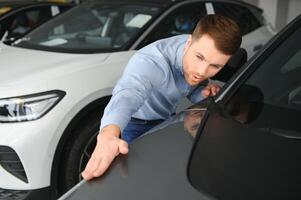 Mens volwassen klant mannetje koper cliënt kiest auto wil naar kopen nieuw auto- foto