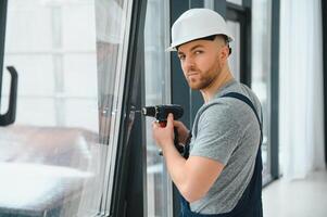 bouw arbeider installeren venster in huis foto