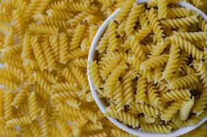 droog fusilli pasta in kom voor Koken foto