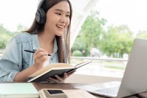 mooi Aziatisch vrouw vrouw leerling opgewonden controle taal test resultaten Aan laptop. glimlach meisje gelukkig studie online. boek in college campus. portret vrouw Aan Internationale Azië Universiteit. foto