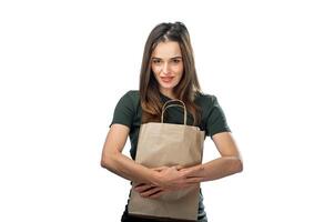 een vrouw Holding een bruin papier zak foto