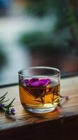 ai gegenereerd elegant glas van thee met een drijvend Purper bloem foto