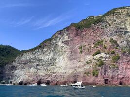 een boot is in de water in de buurt een klif met roze rotsen foto
