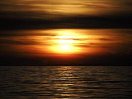 gouden zon stralen reflectie Aan de zee Bij zonsondergang foto