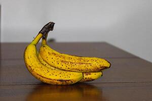 rijp banaan bundel met donker vlekken Aan tafel 2 foto